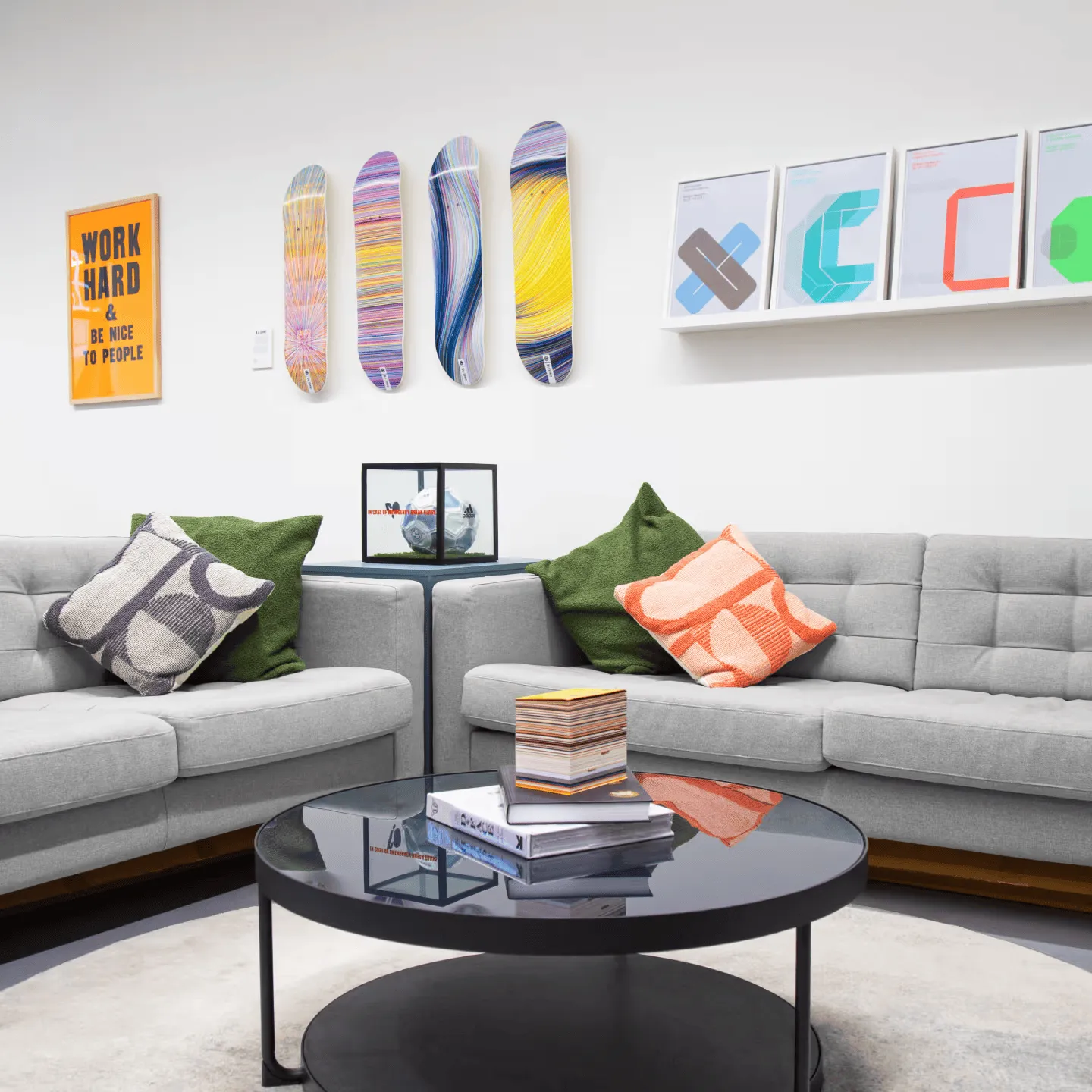 Modern lounge area inside the Rhapsody London office with sofas, artwork, and a round coffee table