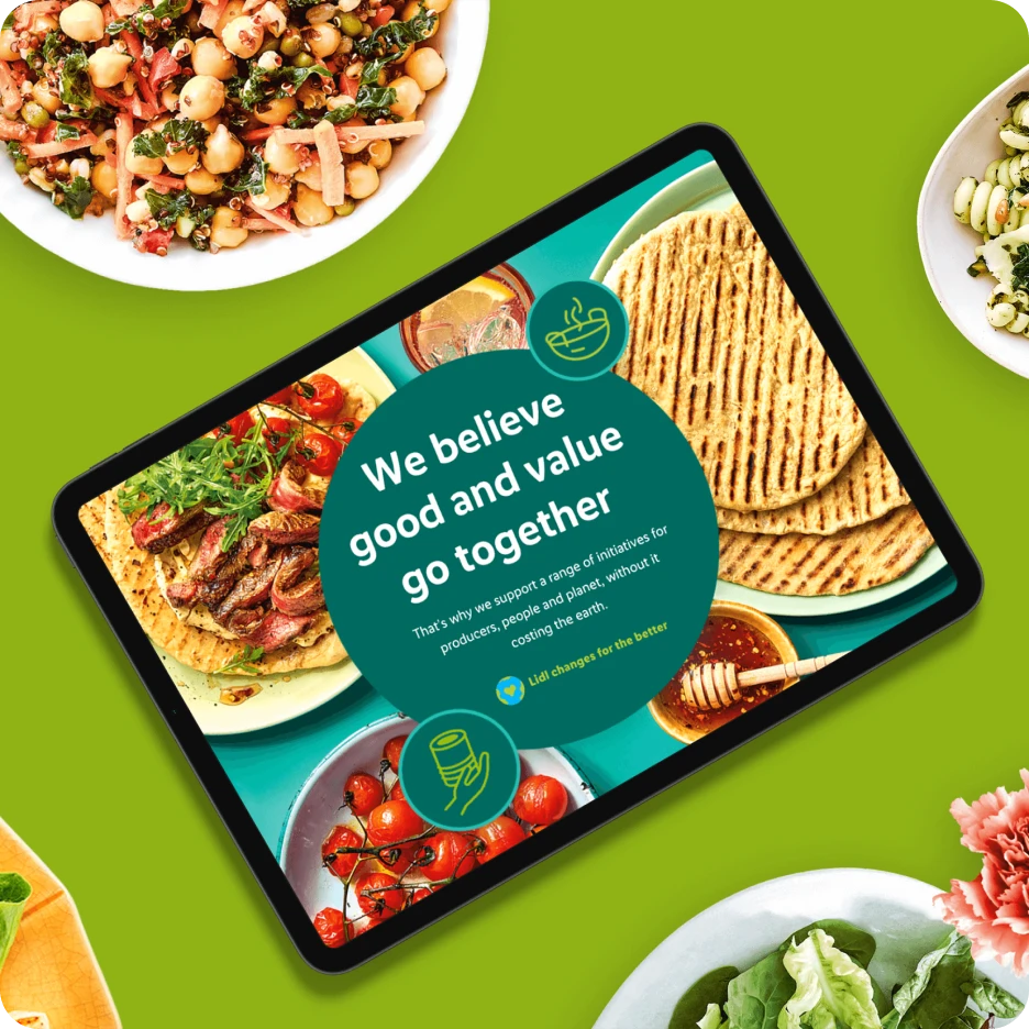 Tablet displaying sustainable food brand campaign design surrounded by healthy dishes and fresh ingredients