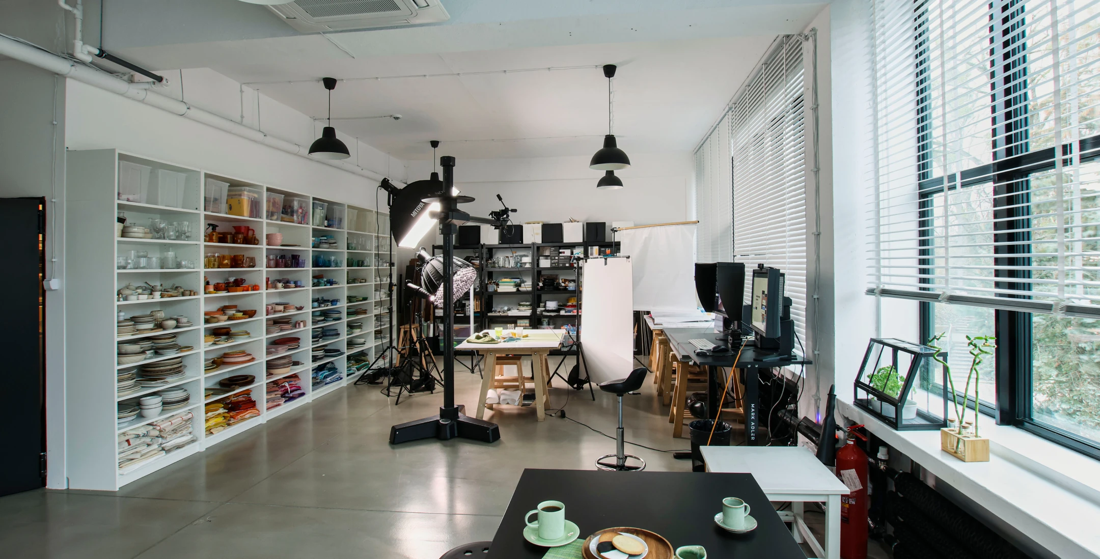 Professional food styling studio with prop shelves, lighting equipment and preparation tables for food photography