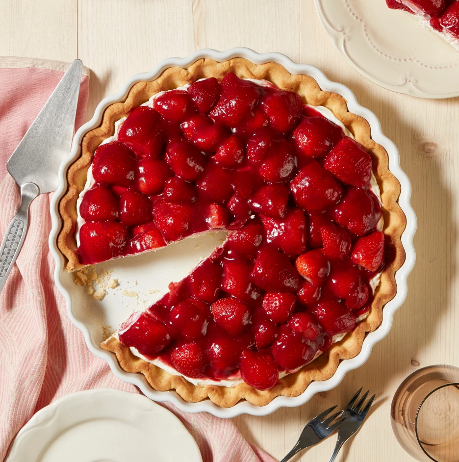 Styled strawberry tart dessert with fresh strawberries and cream on a wooden table for food photography